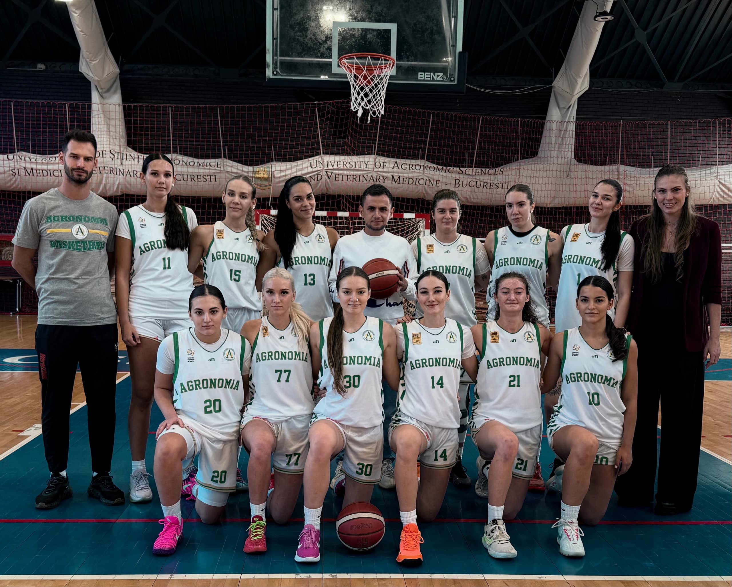 Echipa feminină de baschet și staful, în fața bannerului U.S.A.M.V.