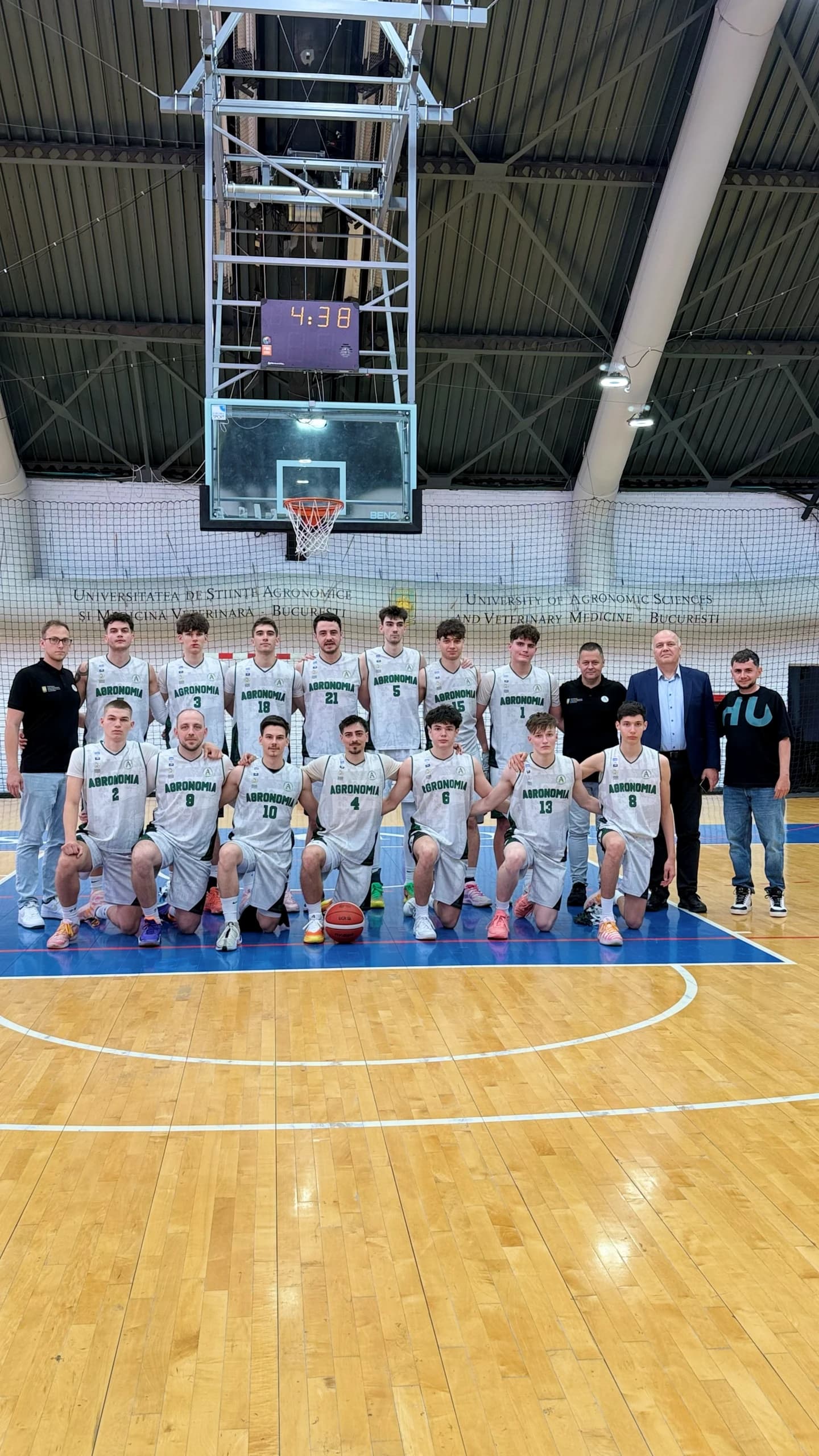 Echipa masculină aliniată sub panou, alături de oficiali