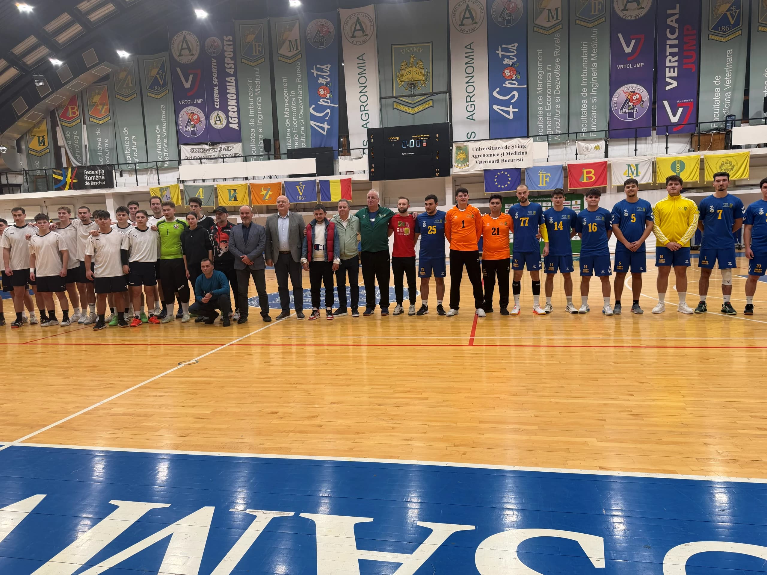 Cele două echipe aliniate pe tușă, în sala din campus