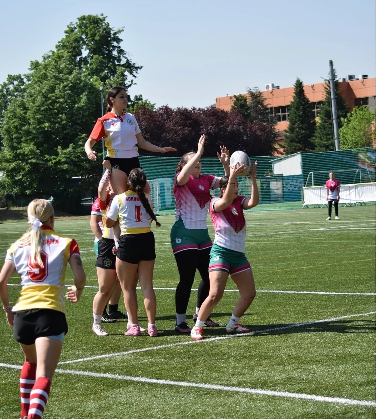 Fază de margine la rugby: jucătoarea ridicată de coechipiere prinde mingea