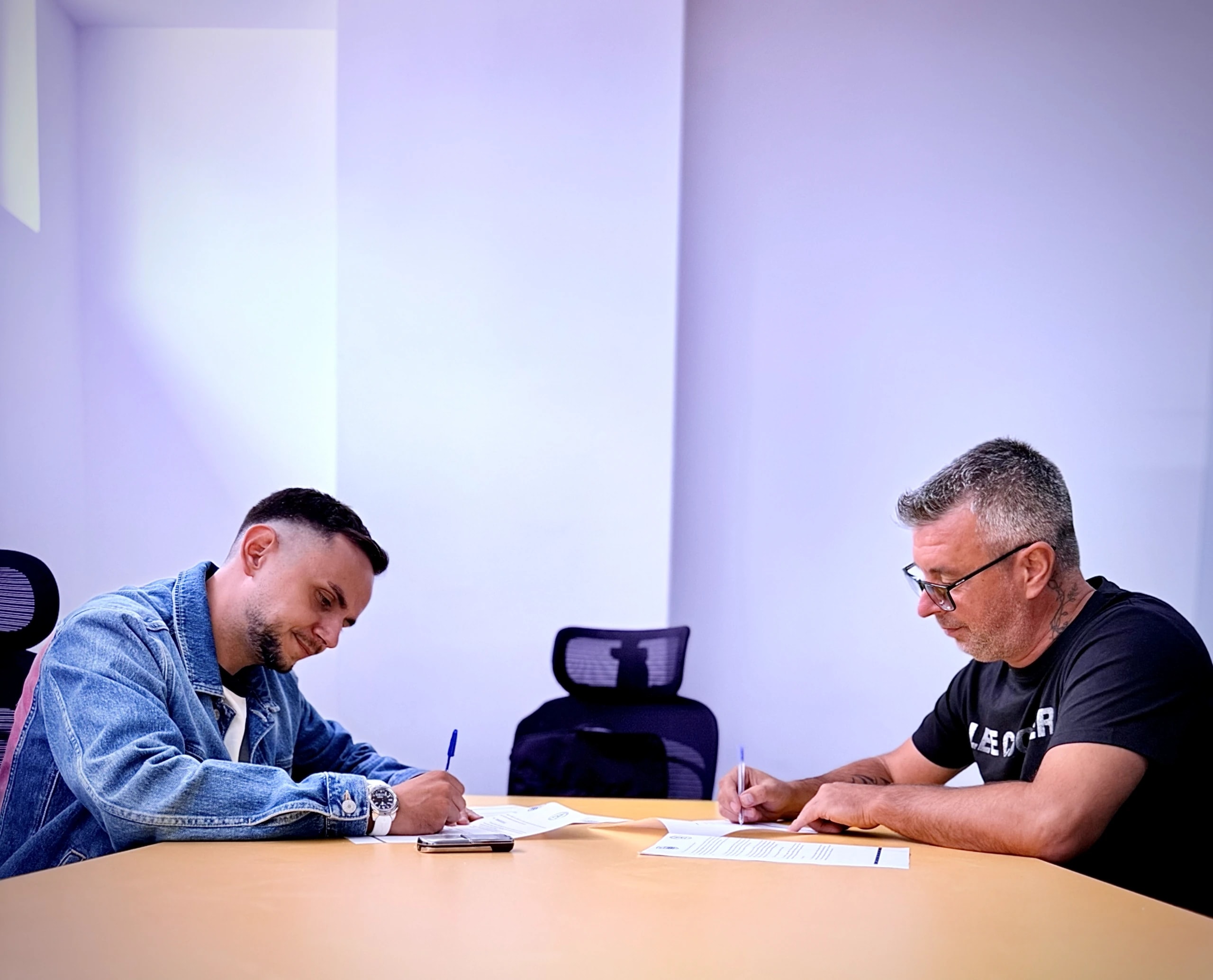 Semnarea acordului de parteneriat, la masa de ședință, de către reprezentanții celor două cluburi