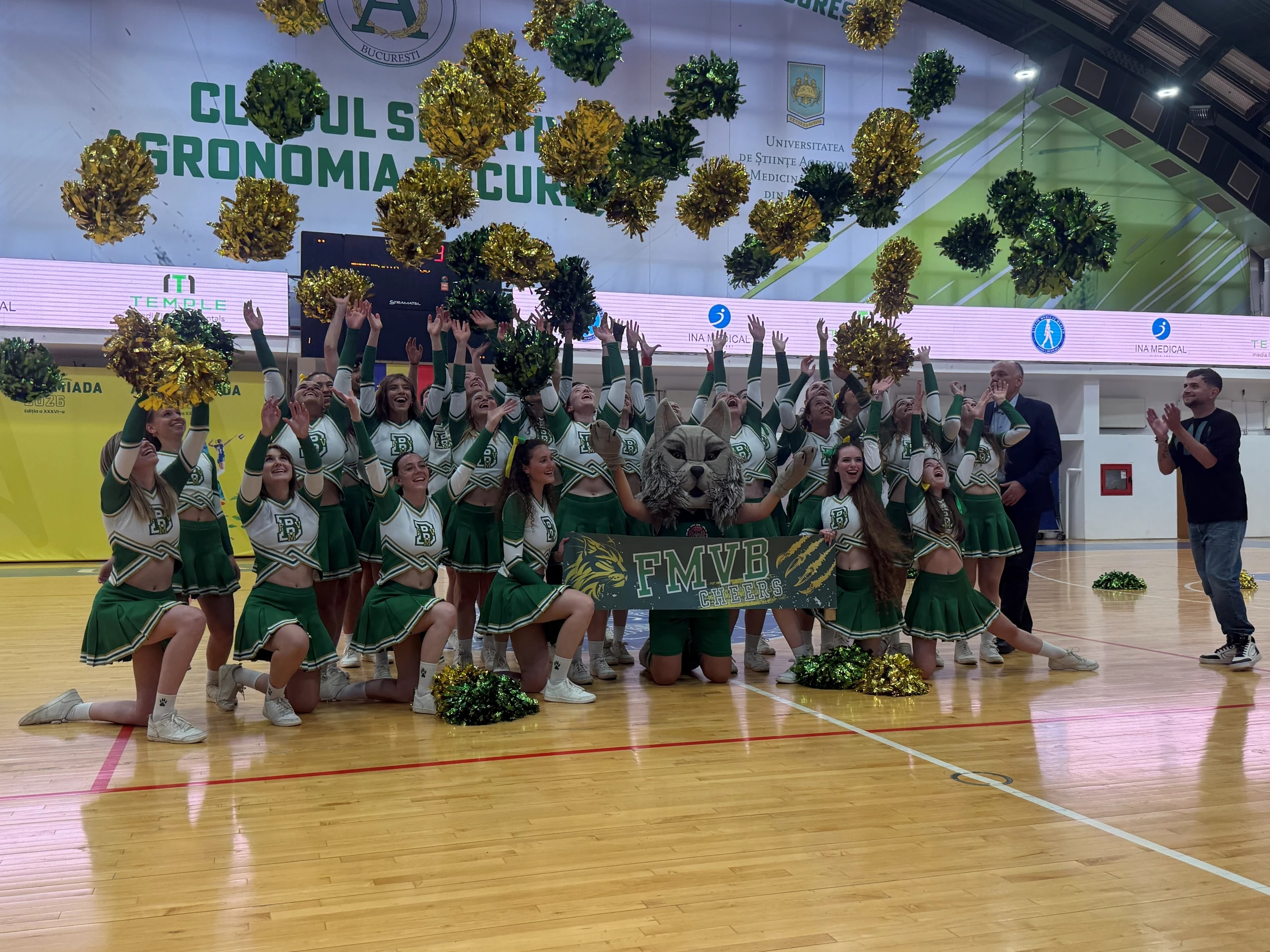 Majoretele F.M.V.B. și mascota clubului, cu brațele ridicate la mijlocul terenului