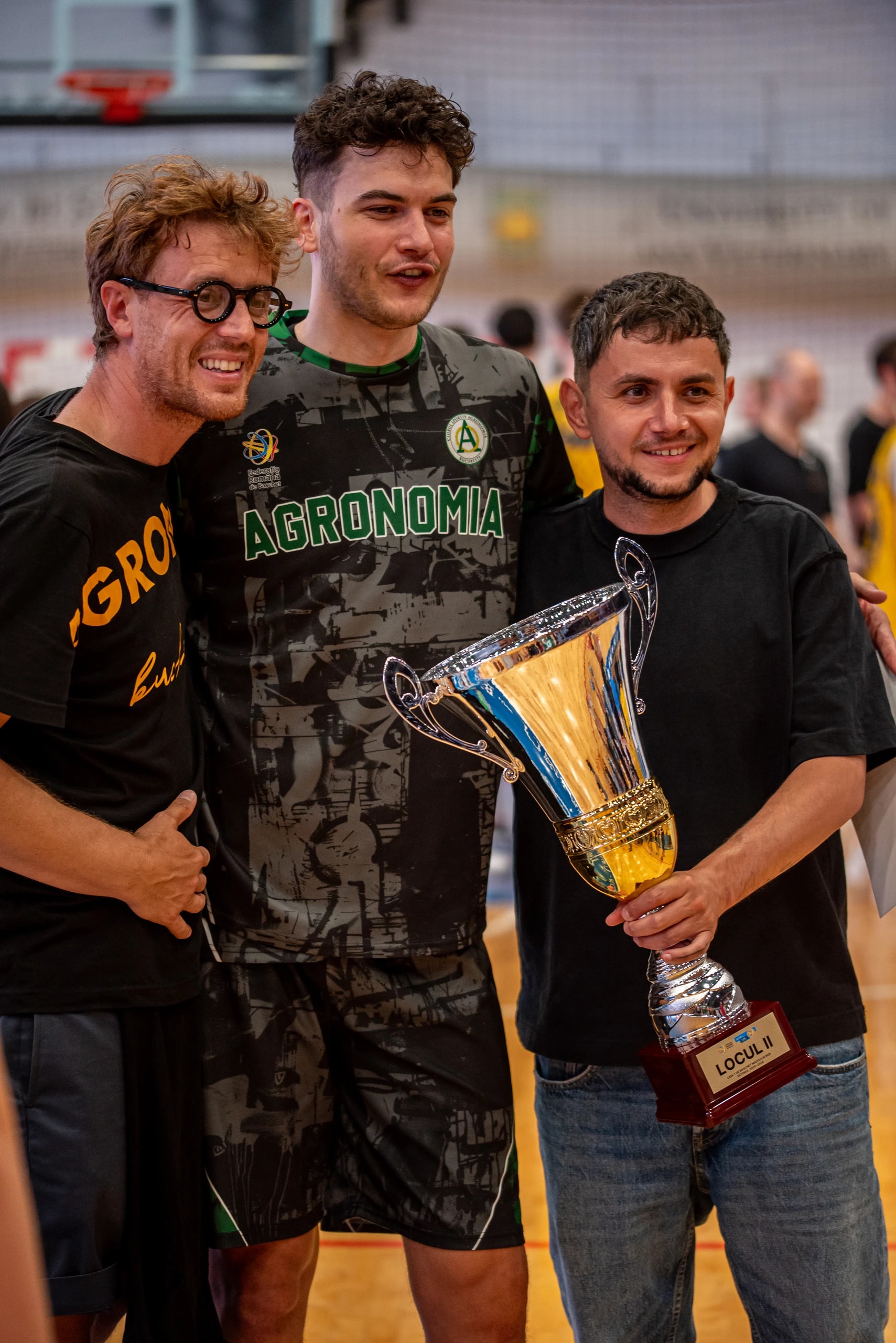 Un jucător al Agronomiei și doi membri ai staffului, cu trofeul pentru locul II