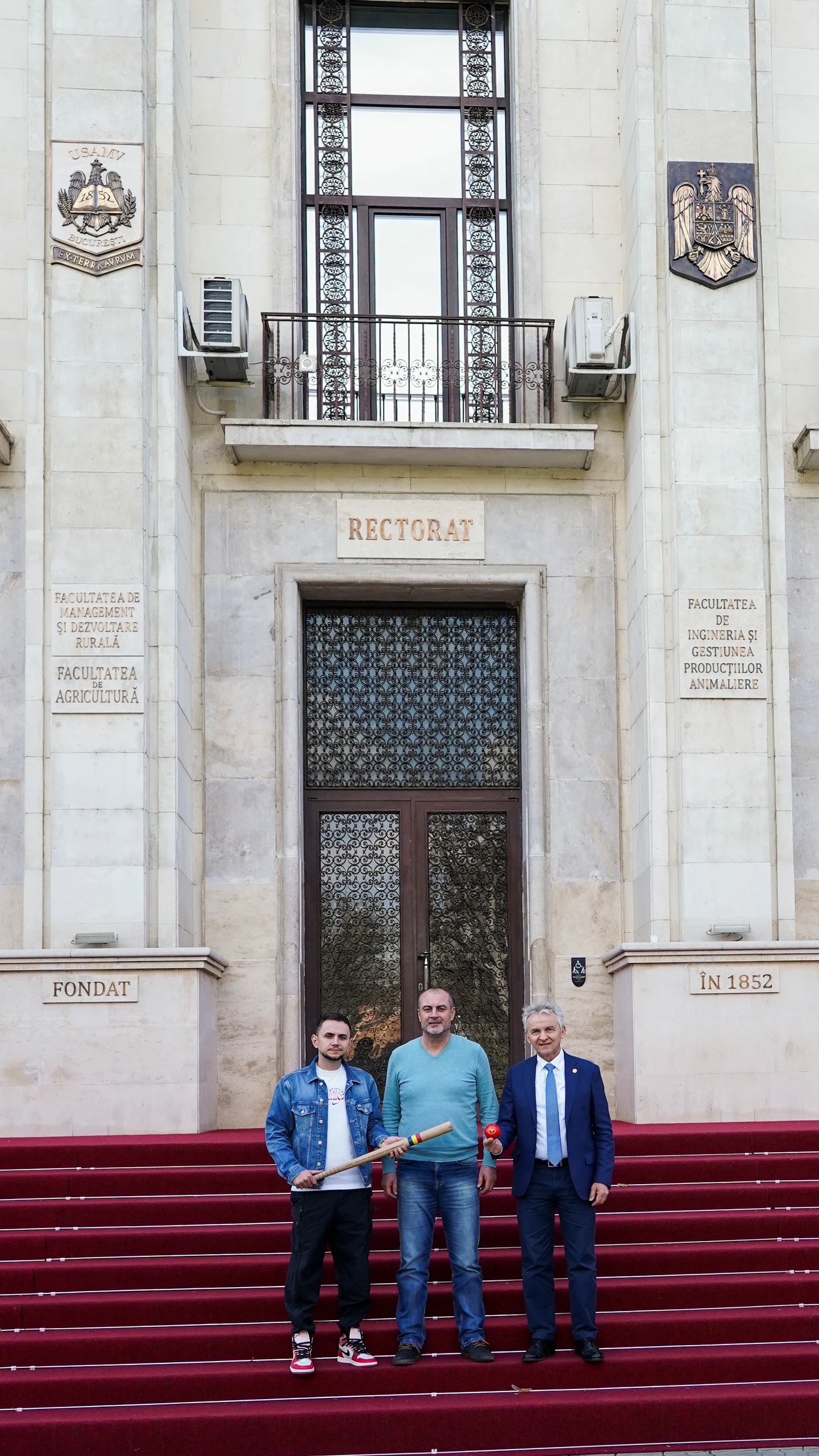 Trei reprezentanți ai clubului pe treptele Rectoratului U.S.A.M.V., cu bâta și mingea de oină